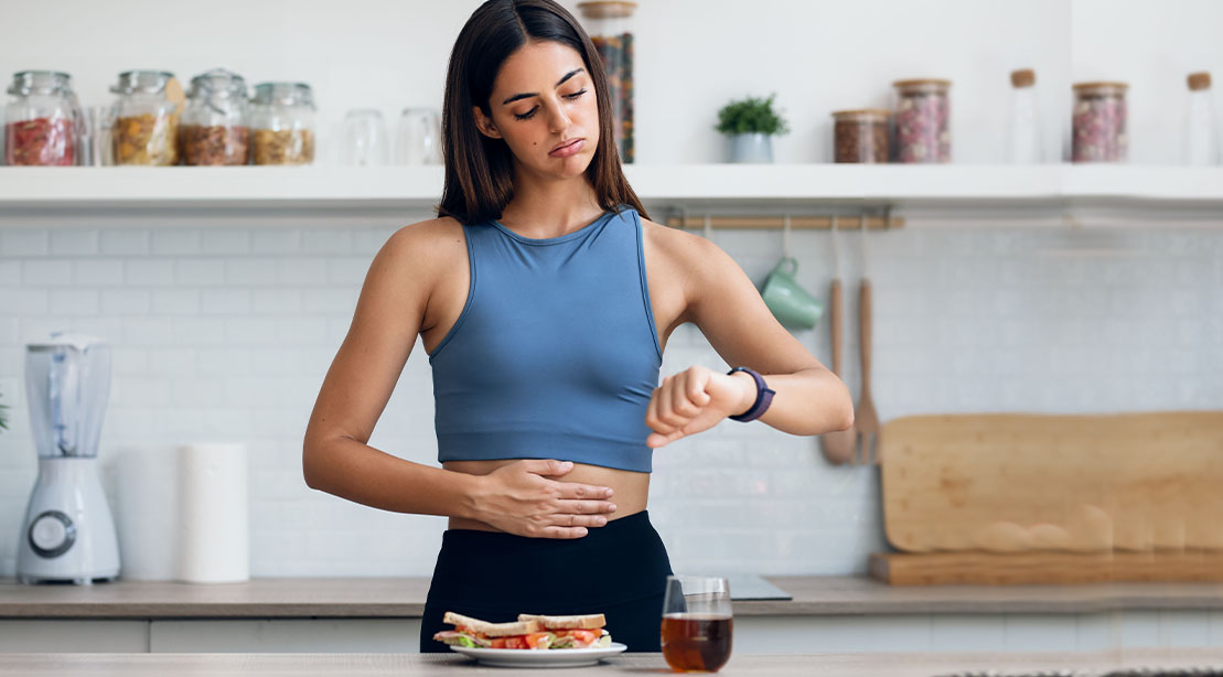 Female on a diet to lose weight checking her watch for the best window for intermittent fasting