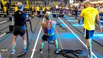 Fit female competitors performing sled pulls in a Hyrox competition