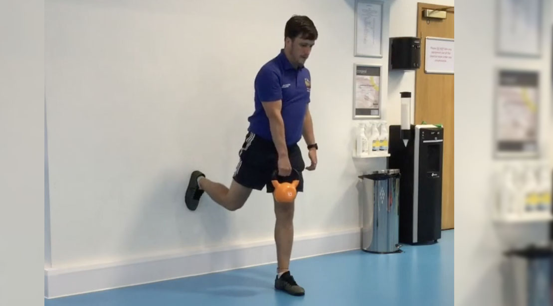Man performing a single leg Wall RDL