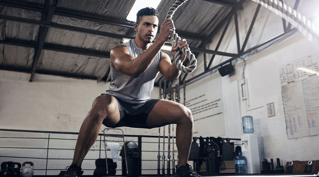 Man performing strength based cardio workouts using battle ropes to lose weight without a treadmill